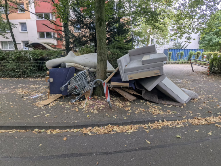 Müll neben einem Baum auf dem Bürgersteig